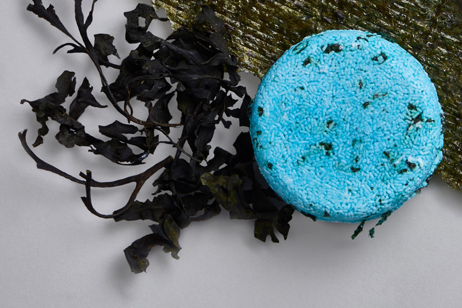 A blue shampoo bar sits on top of ingredients nori seaweed and Irish moss.